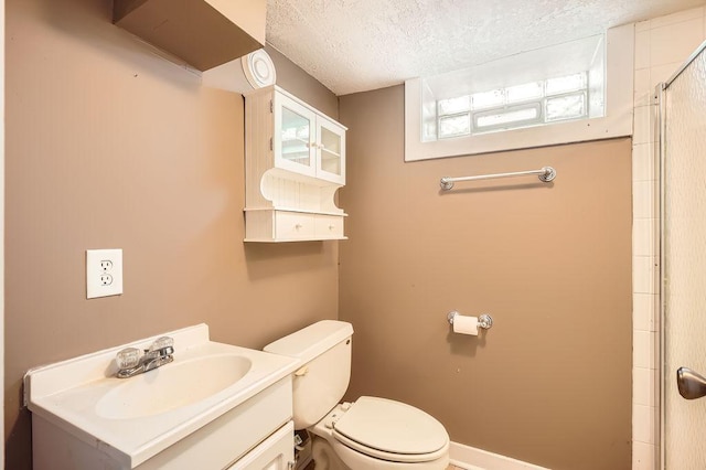 full bathroom featuring toilet, a shower, vanity, and a textured ceiling