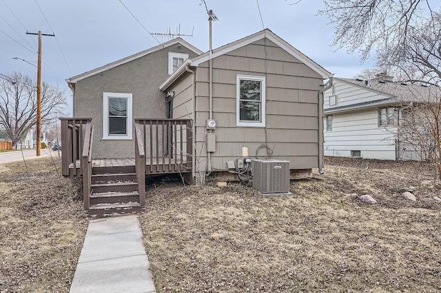 rear view of house with a deck and central AC