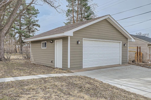 detached garage featuring fence