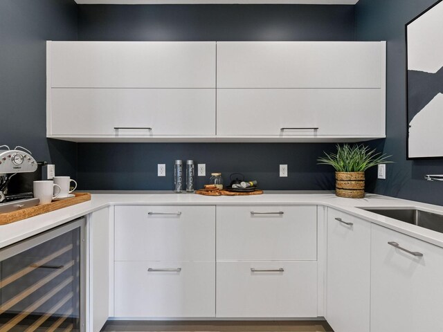 251 Glenbrook Rd N, Wayzata, MN 55391 - kitchen featuring wine cooler, white cabinetry, a sink, and light countertops