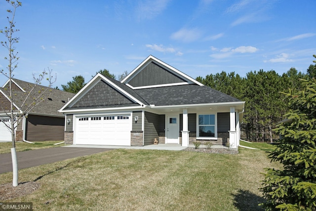 craftsman-style home with aphalt driveway, a front yard, stone siding, an attached garage, and a shingled roof