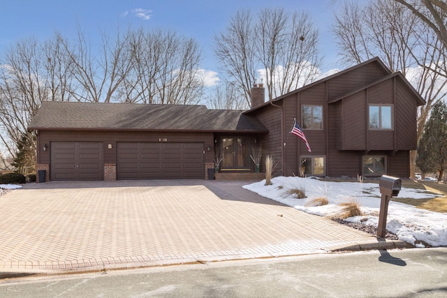 1001 Gramsey Pl, Burnsville, MN 55306 - view of front of property featuring a chimney, an attached garage, and driveway