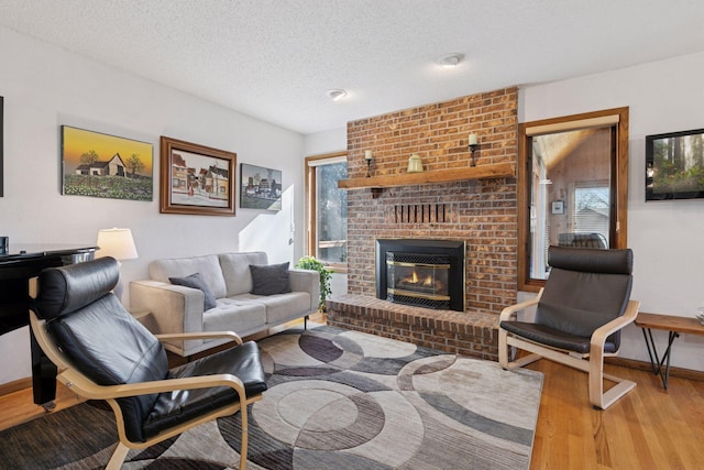 1001 Gramsey Pl, Burnsville, MN 55306 - living area featuring wood finished floors, a fireplace, baseboards, and a textured ceiling