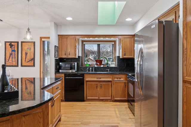 1001 Gramsey Pl, Burnsville, MN 55306 - kitchen featuring black appliances, a sink, brown cabinets, light wood-style floors, and backsplash