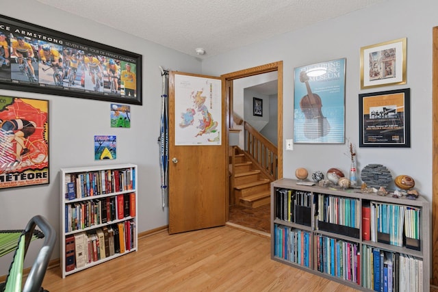 1001 Gramsey Pl, Burnsville, MN 55306 - sitting room featuring wood finished floors, a textured ceiling, and stairway