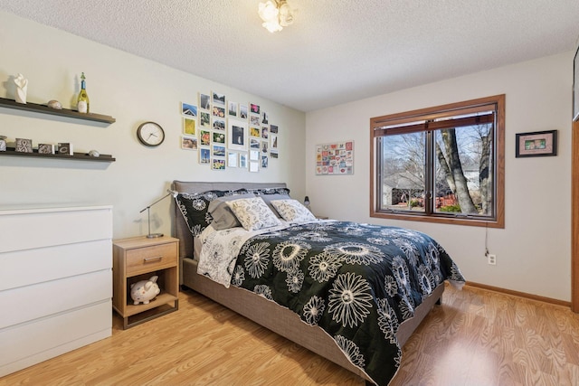 1001 Gramsey Pl, Burnsville, MN 55306 - bedroom featuring light wood-style floors, a textured ceiling, and baseboards