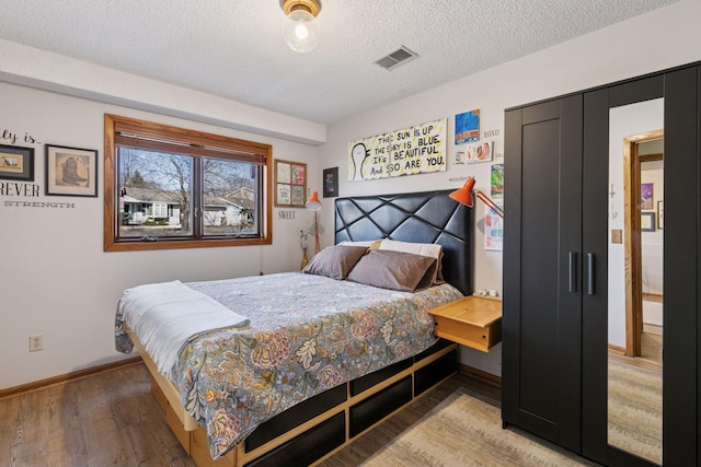 1001 Gramsey Pl, Burnsville, MN 55306 - bedroom featuring light wood finished floors, baseboards, and a textured ceiling