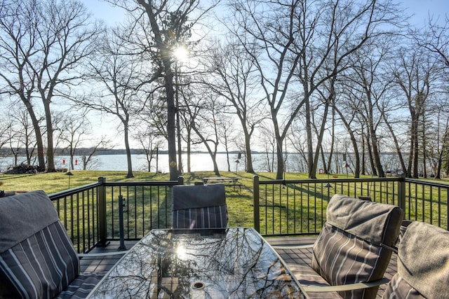 wooden deck with a lawn and a water view