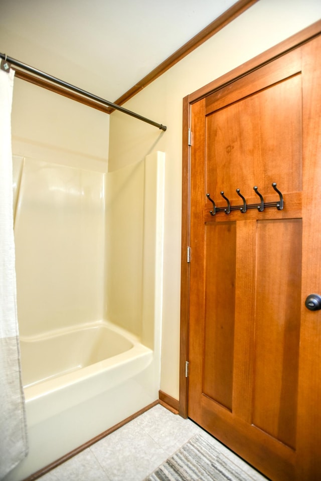 bathroom with crown molding, shower / bathtub combination with curtain, and tile patterned floors
