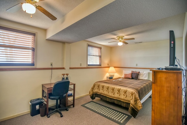 bedroom with baseboards, ceiling fan, carpet, and a textured ceiling