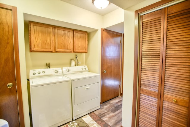 washroom featuring light wood-type flooring, cabinet space, and washing machine and clothes dryer