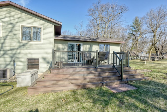 rear view of property featuring a yard, central AC unit, and a wooden deck