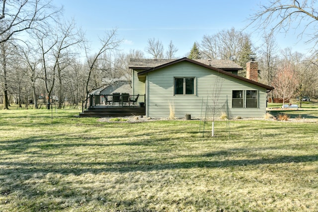view of side of home featuring a lawn, a chimney, and a wooden deck
