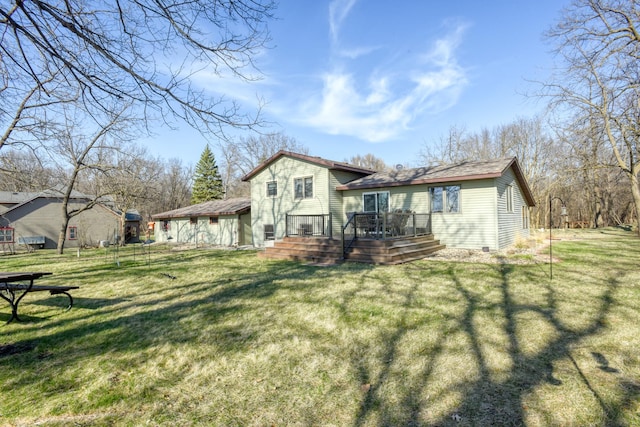 rear view of house with a wooden deck and a yard