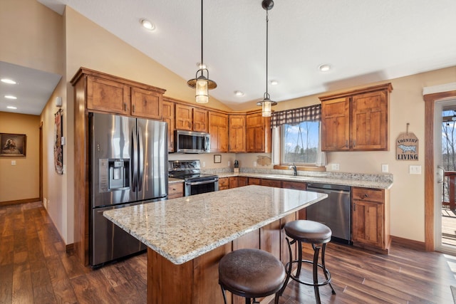 kitchen with brown cabinetry, baseboards, dark wood-style floors, and stainless steel appliances