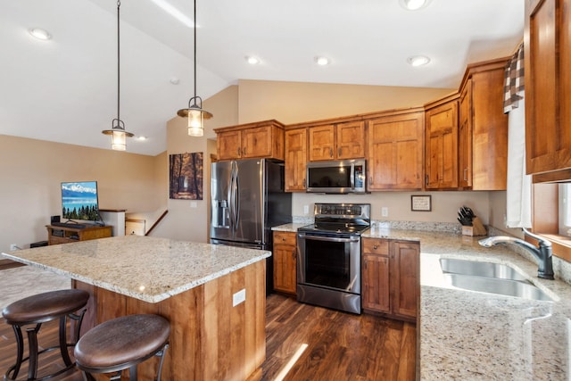 kitchen featuring dark wood finished floors, brown cabinetry, appliances with stainless steel finishes, a sink, and lofted ceiling