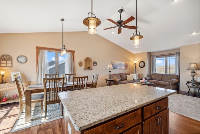 kitchen with pendant lighting, dark wood-style flooring, a ceiling fan, and vaulted ceiling