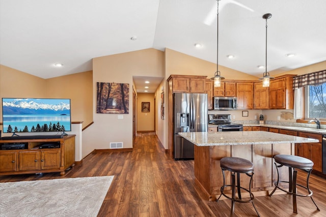 kitchen with visible vents, dark wood finished floors, brown cabinets, vaulted ceiling, and stainless steel appliances