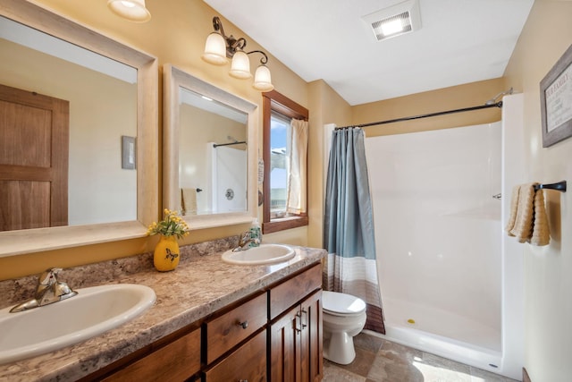 bathroom featuring a sink, visible vents, toilet, and a stall shower
