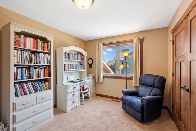 sitting room with light carpet, visible vents, and baseboards