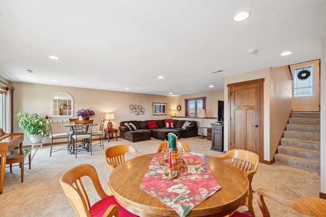 dining room featuring visible vents, recessed lighting, light carpet, and stairs