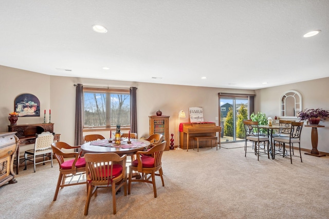 dining area with light carpet, a healthy amount of sunlight, and recessed lighting
