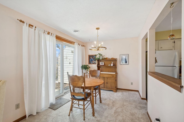 dining room featuring visible vents, baseboards, an inviting chandelier, and light carpet