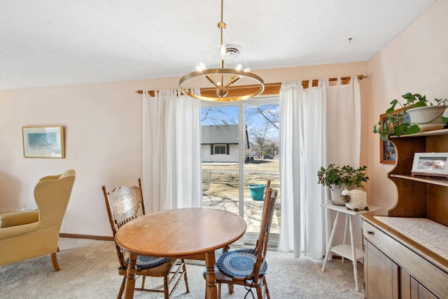 dining area featuring a chandelier, a textured ceiling, light colored carpet, and visible vents
