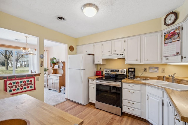 kitchen with visible vents, a sink, freestanding refrigerator, electric stove, and under cabinet range hood