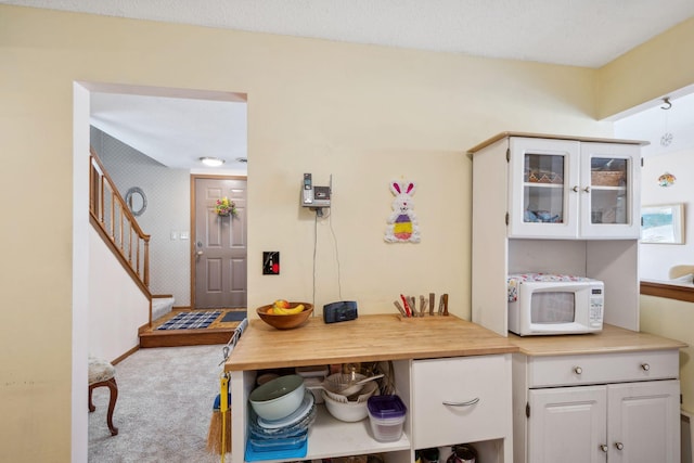 carpeted dining room with stairs