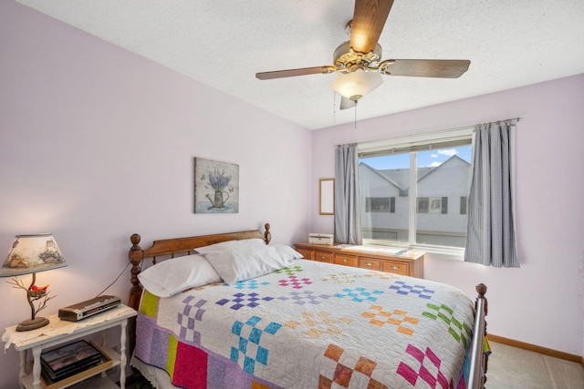 bedroom featuring a textured ceiling, ceiling fan, baseboards, and carpet