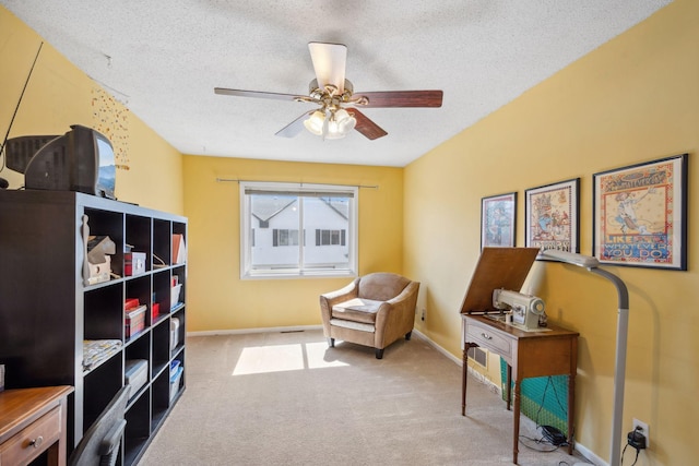 sitting room featuring ceiling fan, carpet flooring, baseboards, and a textured ceiling