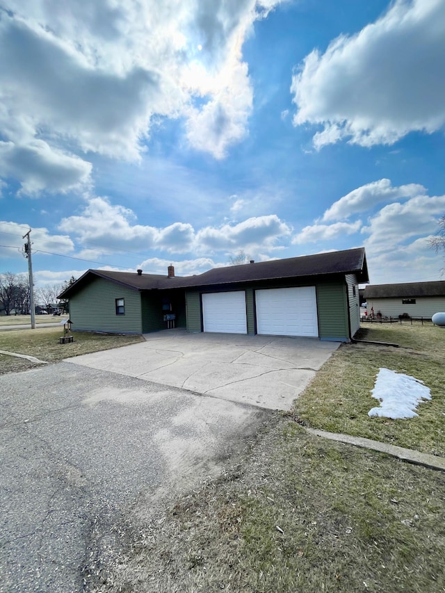 view of front of house with a garage, a front yard, and driveway