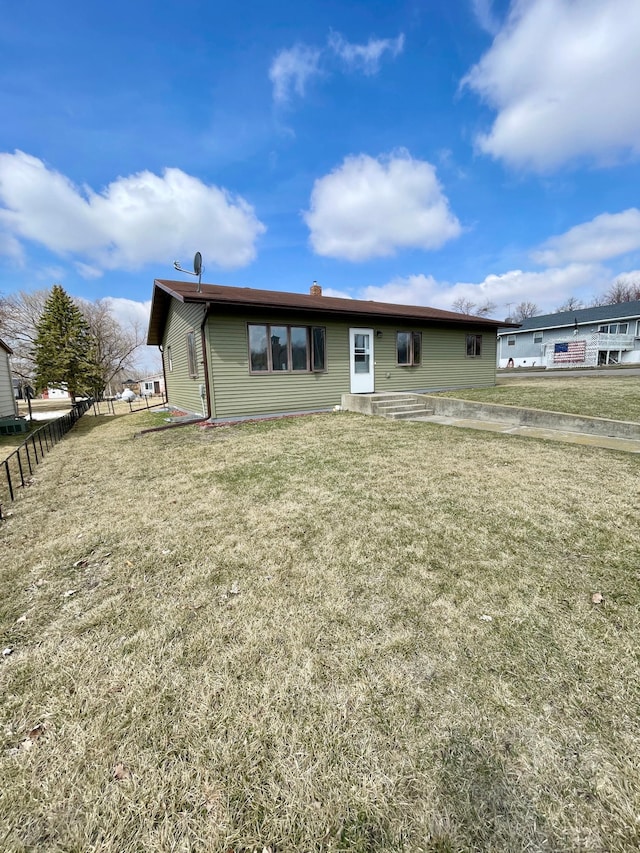 view of front facade featuring a front lawn, fence, and a chimney
