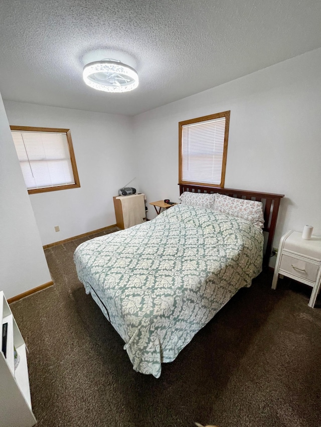 bedroom featuring carpet floors, baseboards, and a textured ceiling