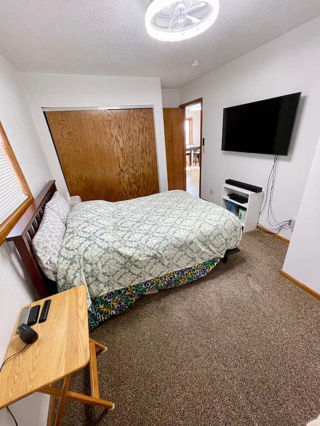 carpeted bedroom featuring a closet, baseboards, and a textured ceiling