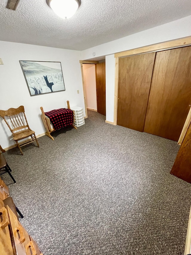 living area with a textured ceiling and carpet