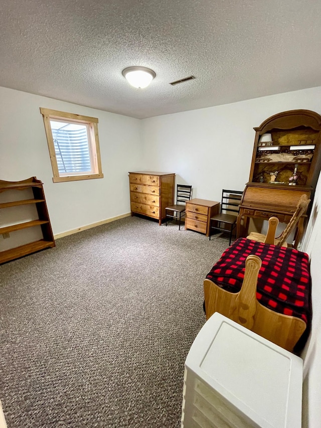 living area featuring visible vents, baseboards, carpet flooring, and a textured ceiling