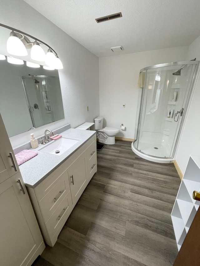 full bathroom featuring visible vents, a stall shower, wood finished floors, and a textured ceiling