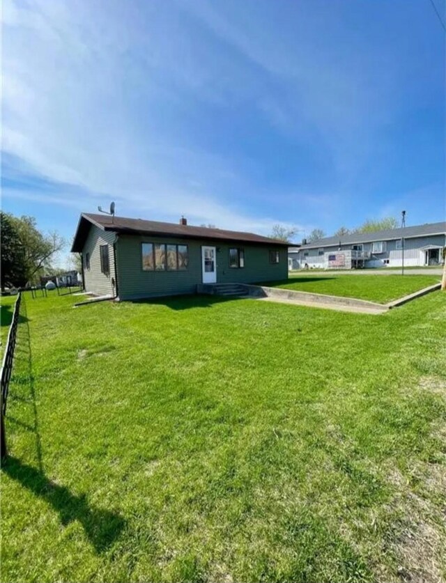 123 3rd St, Bluffton, MN 56518 - rear view of house featuring a lawn