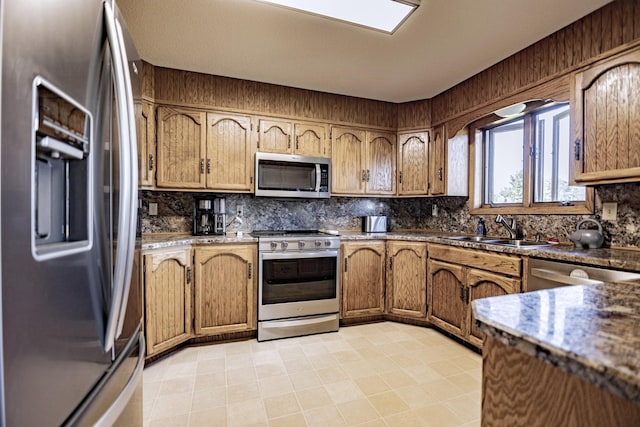 123 3rd St, Bluffton, MN 56518 - kitchen with appliances with stainless steel finishes, decorative backsplash, and brown cabinetry