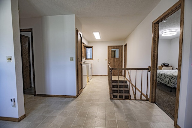 123 3rd St, Bluffton, MN 56518 - hallway featuring separate washer and dryer, light tile patterned floors, and a textured ceiling