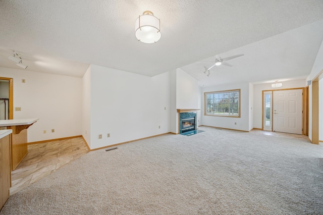2786 87th St E Unit 18, Inver Grove Heights, MN 55076 - unfurnished living room with light colored carpet, track lighting, lofted ceiling, a textured ceiling, and a premium fireplace