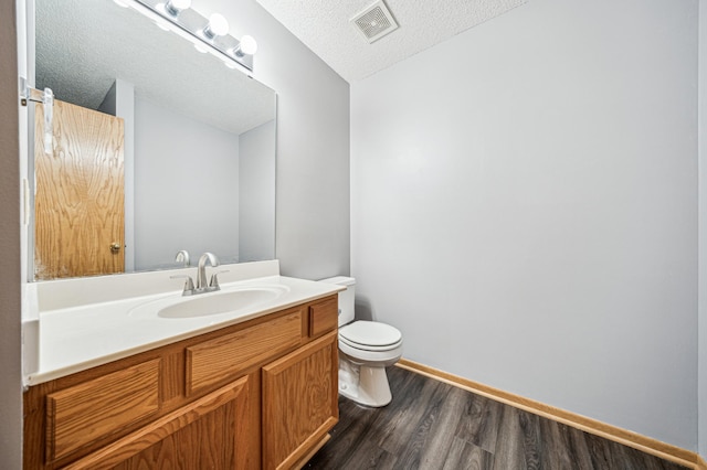 2786 87th St E Unit 18, Inver Grove Heights, MN 55076 - bathroom featuring wood finished floors, toilet, a textured ceiling, baseboards, and vanity