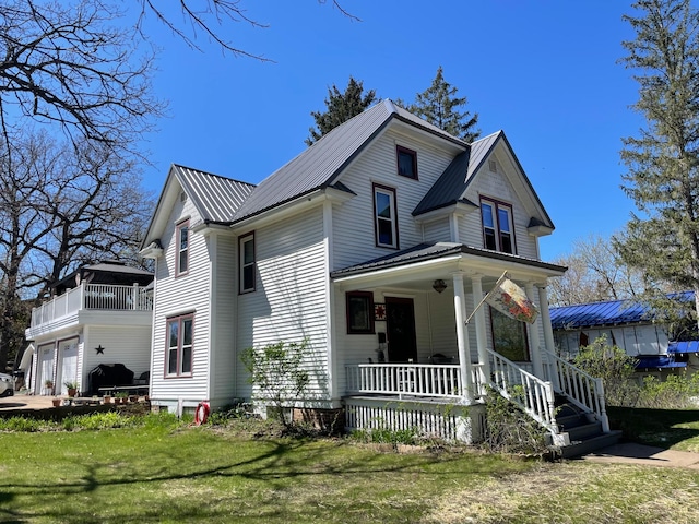 view of front of house with a porch, an attached garage, metal roof, and a balcony