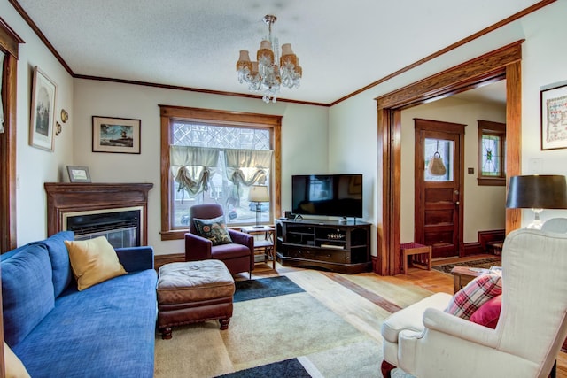 living room featuring a chandelier, wood finished floors, ornamental molding, and a glass covered fireplace
