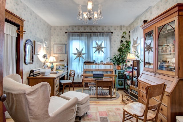 sitting room featuring light wood-type flooring, a chandelier, and wallpapered walls