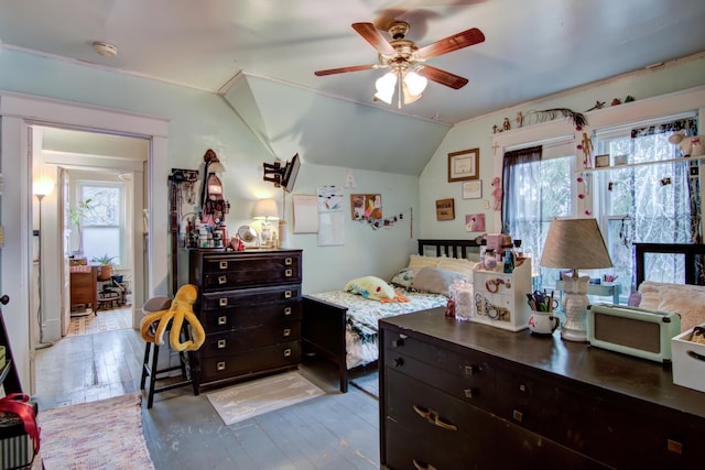 bedroom with multiple windows, light wood-style floors, vaulted ceiling, and a ceiling fan