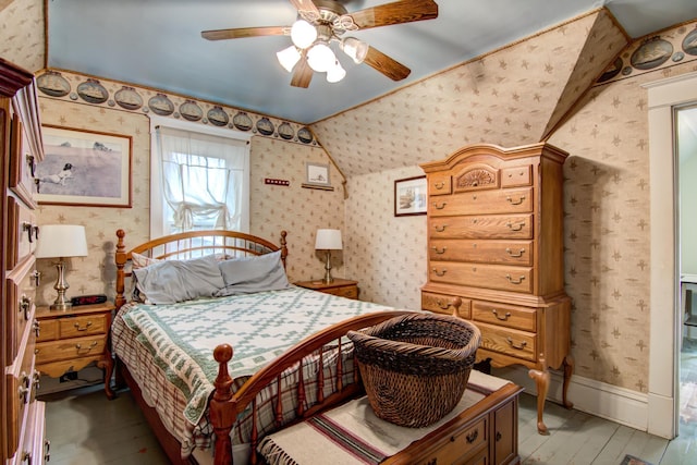 bedroom featuring lofted ceiling, ceiling fan, light wood-style floors, and wallpapered walls