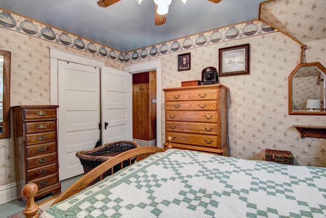 bedroom featuring ceiling fan and wallpapered walls